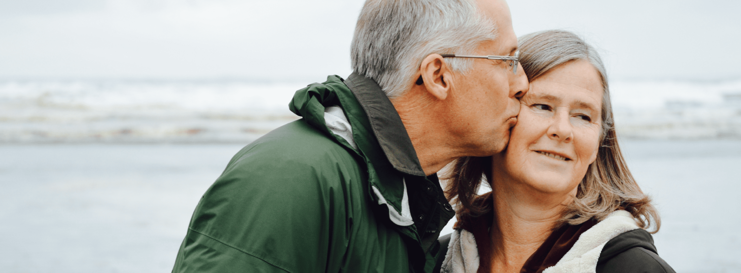 an older man kissing his wife's cheek