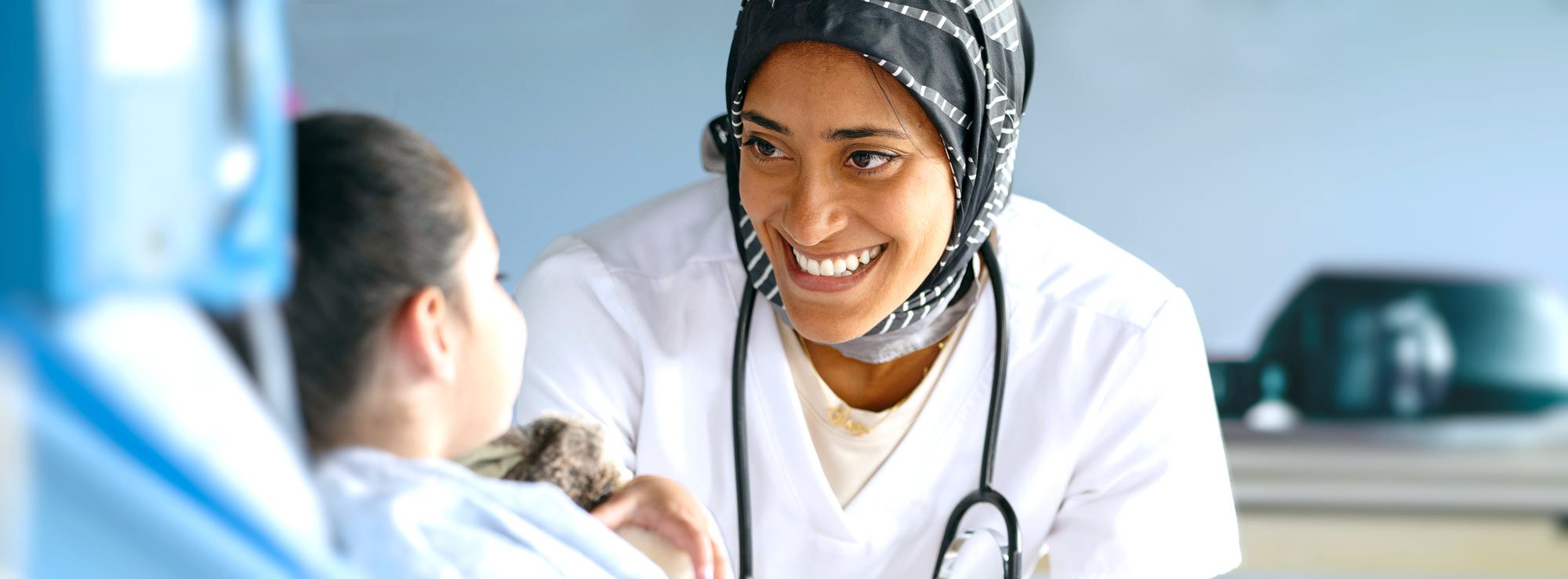 A doctor in a hajib smiles at a young patient at Children's Hospital Los Angeles